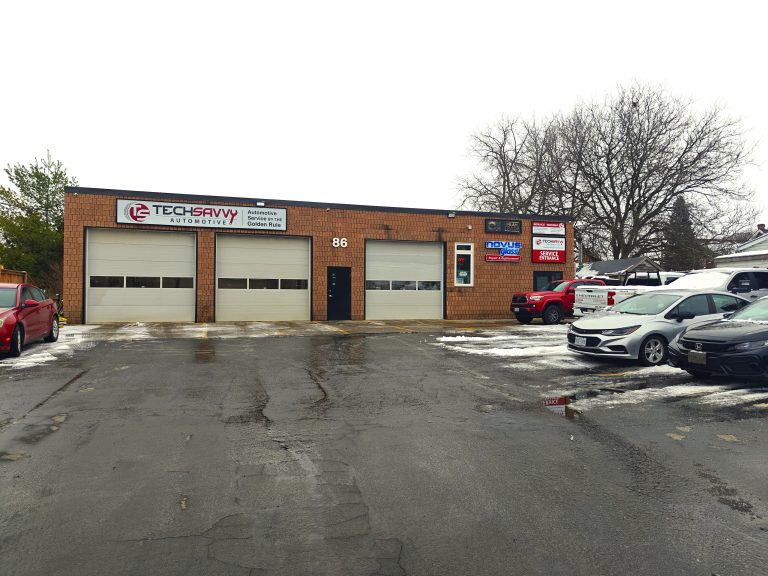 Brick shop building with three service bays seen from the parking lot on a winter day