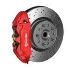 Red Brembo brake caliper mounted on a cross-drilled rotor