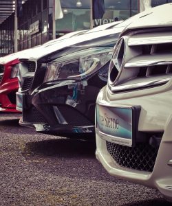 Row of parked car front grilles outside a dealership