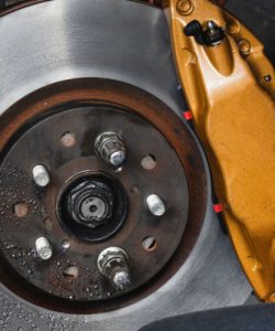 Brake rotor and caliper with a gloved hand alongside