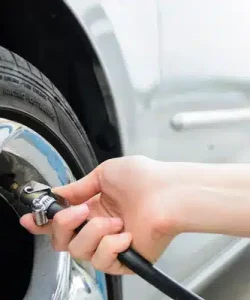 Hand checking tire pressure with a gauge