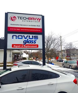 Tech Savvy Automotive and Novus Glass signs on the pole outside the Brantford shop after a snowfall