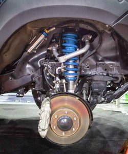 Front coil spring and control arm seen from under a vehicle