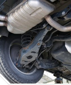 Muffler and exhaust pipe under a vehicle beside the rear tire