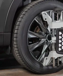 Alignment clamp attached to an SUV wheel in a service bay