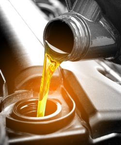 Oil pouring into an engine in warm backlight