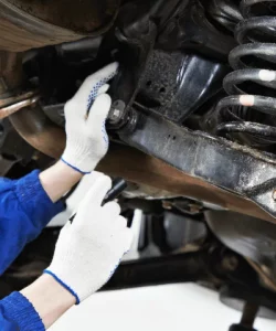 Mechanic working on a front coil-spring suspension assembly